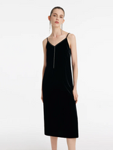 a lady in a silk blend spaghetti strap black midi velvet dress
